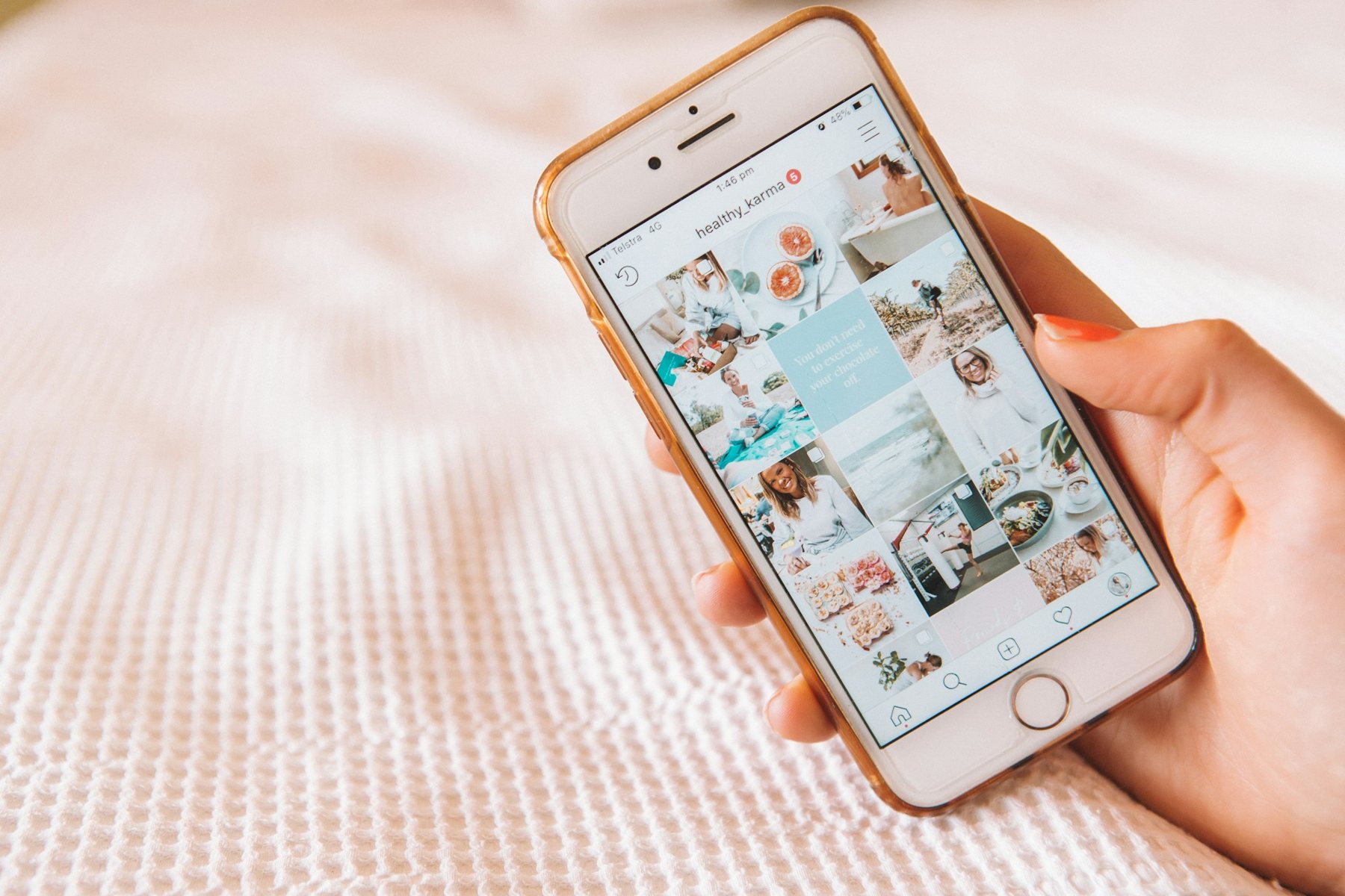 Hand hält ein Smartphone mit Social-Media-Feed